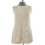 1960s sleeveless mini white dress piped in yellow with paisley pattern shown on dress form against white background