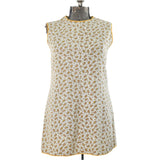1960s sleeveless mini white dress piped in yellow with paisley pattern shown on dress form against white background