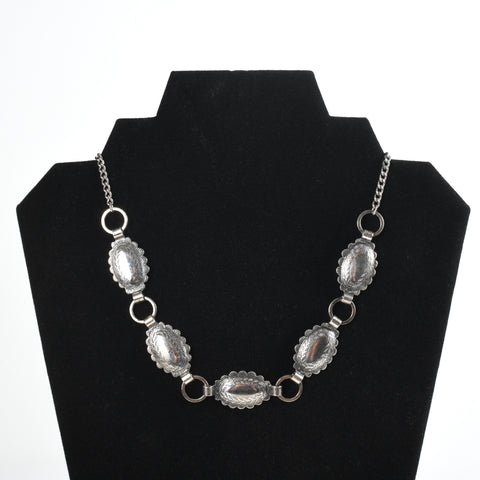 vintage 1950s silver tone concho short costume jewelry necklace shown on black necklace display with white background