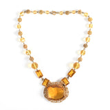 vintage 1930s amber Czech glass brass filigree bead short necklace lying flat on white background