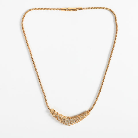 vintage 1970s gold color rope chain 16 inch necklace with V shaped pendant filled with small Swarovski crystals shown lying flat on white background