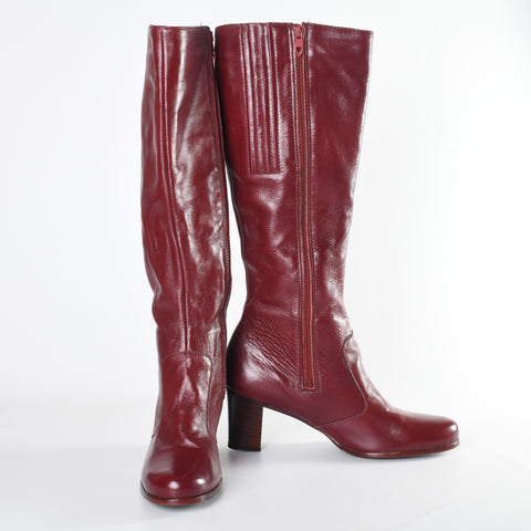 vintage 1970s Oxblood Red Leather Tall Zipper side boots with left image boot facing foward and right image boot turned to show inner zipper and side angle sitting on white background
