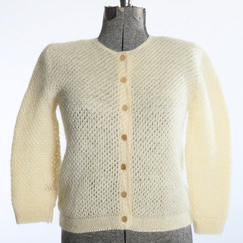 vintage 1950s warm cream diamond patter knit cardigan sweater on dress form with with backdrop