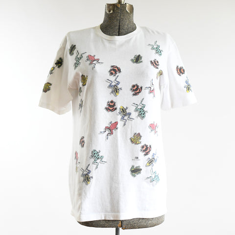 vintage 90s nature themed colorful poison dart frogs scattered all over white cotton tee shirt material shown on dress form with white background