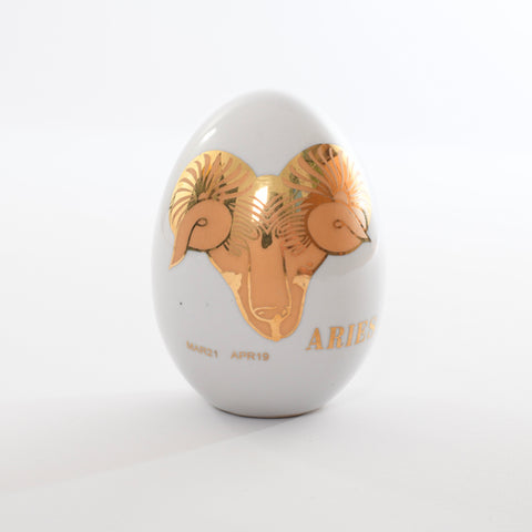 true vintage 1970s white ceramic egg with matte gold ram with metallic gold outline and detailing showing MAR21 APR19 and ARIES printed on egg shown on white background
