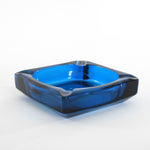 vintage 1970s blue bluenique color square 6 inch ashtray with 4 curved cigarette rests on each corner shown angled all on white background