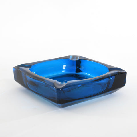 vintage 1970s blue bluenique color square 6 inch ashtray with 4 curved cigarette rests on each corner shown angled all on white background