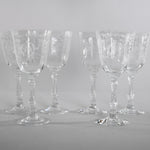 true vintage 1980s clear etched crystal stemmed water goblets shown with 4 lined in back and 2 in front shown on a gray background