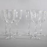 true vintage 1980s clear etched crystal stemmed water goblets shown with 4 lined in back and 2 in front shown on a gray background