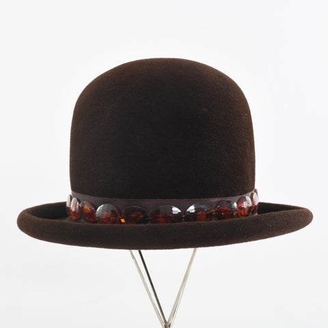 true vintage brown deep crown rolled brim felted wool hat with brown grosgrain crown trim with tortoise shell brown plastic oval beads shown on thin silver hat stand all on white background