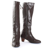 true vintage 1970s chocolate brown tall leather heeled boots shown with left boot facing forward and other boot turned toward right all on white background