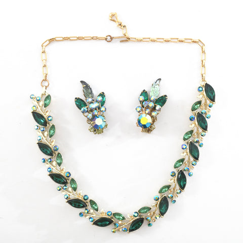 true vintage 1950s emerald green marquis rhinestones offset with smaller lighter green marquis cut rhinestone and smaller round aurora borealis blue rhinestones in a linked panel necklace wiht gold tone metal with matching clip on earrings in middle of necklace shown lying flat on white surface