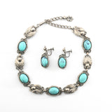 true vintage 1950s faux turquoise and silver tone leaf alternating panel necklace with latch hook closure and matching screw back dangle earrings in center of necklace lying flat on white background 