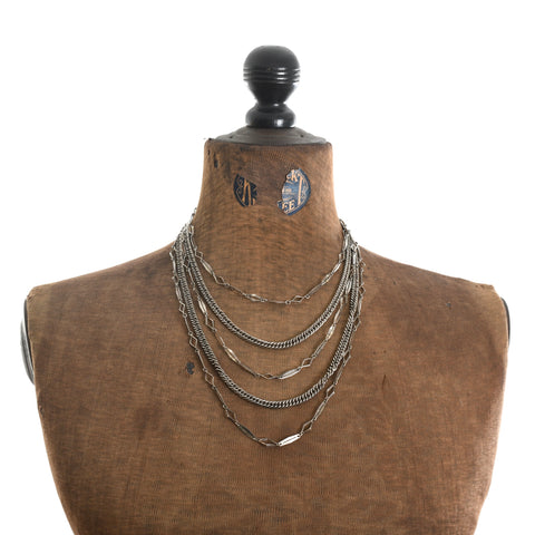 true vintage 1960s silver 5 strand tiered bib necklace shown on dress form against white background 