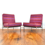 true vintage 1960s purple red orange stripe parallel bar lounge chair set by florence knoll shown angled toward each other on hardwood floor and white wall