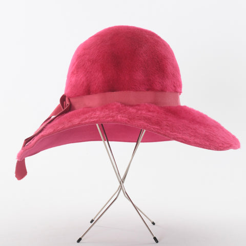 true vintage 1970s fuchsia pink felted fur wide brim floppy bucket hat with pink ribbon around crown shown on 4 thin leg silver metal hat stand on white background