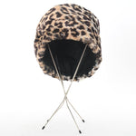 true vintage 1960s faux fur leopard print hat with black interior lining shown angled towards back on 4 thin leg silver metal hat stand on white background