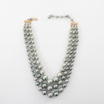 true vintage 1960s blue gray faux pearl graduated bead 3 strand necklace shown lying flat on white background