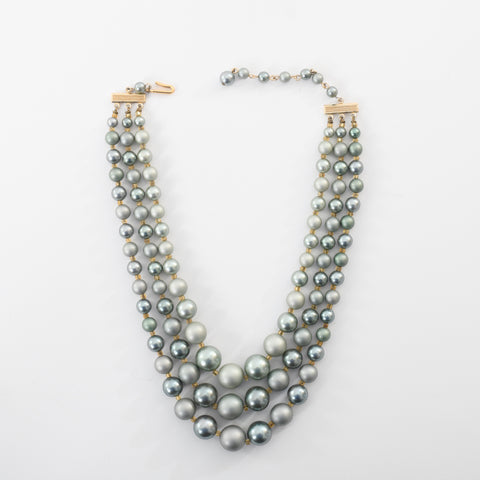 true vintage 1960s blue gray faux pearl graduated bead 3 strand necklace shown lying flat on white background