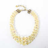 true vintage 1950s yellow iridescent 3 strand aurora borealis crystal beaded necklace shown lying in a circle on white background