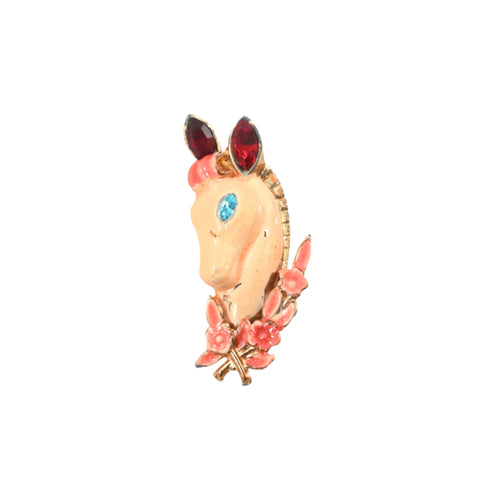 true vintage 1940s peach horse head with pink victory wreath around neck, ice blue rhinestone eye and red rhinestone ears brooch shown lying flat on a white background