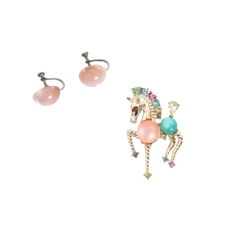 true vintage 1960s pink green lucite moonstone jelly belly rhinestone horse gold tone metal brooch with pink moonstone silver screwback earrings shown lying flat on whitebackground