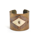 true vintage wide sheet metal cuff with 2 layered diamond shapes held on with 4 rivets shown sitting facing forward on white background