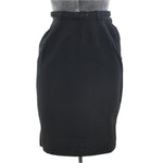 true vintage 1950s black pencil skirt with arrow waistband darts pointing down with original black matching belt shown on dress form against white background