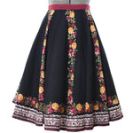 true vintage 90s does 50s roses border print on black main body full circle skirt shown on dress form against white background