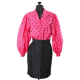 true vintage 1980s hot pink bishop sleeve with black flocked polka dots and matching black polka dot skirt shown on dress form against white background