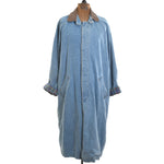 true vintage 1990s blue denim long duster coat with tab collar in brown leather and sleeves rolled up showing plaid flannel on dress form with white background