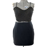 true vintage 1980s 2 piece black gold polka dot mesh cropped bustier top with black spaghetti straps and solid black mini skirt shown on dress form against white background