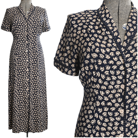 vintage 1990s navy blue maxi dress with cream and beige cups and saucers novelty print on entire dress  with button front and short sleeves shown on dress form left image and close up of bodice in right image shown on white background 