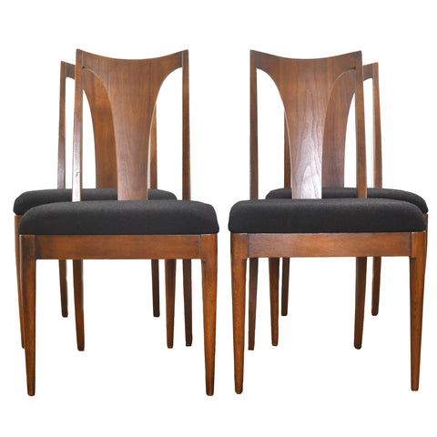 true vintage 1960s set of 4 brown walnut curved t back side dining chairs with black upholster shown with 2 chairs in front and two in back shown on white background