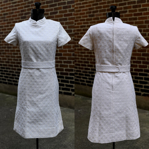 vintage 1960s mod white mini dress with nautilus swirl pattern shown on left image facing forward on dress form and right side of image back of dress both against a brick wall