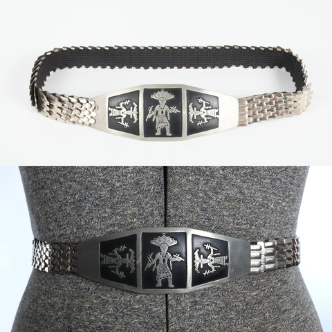 vintage 1960s silver scale stretch belt with wide 3 kachina doll buckle shown lying on white background top image and on dress form lower image