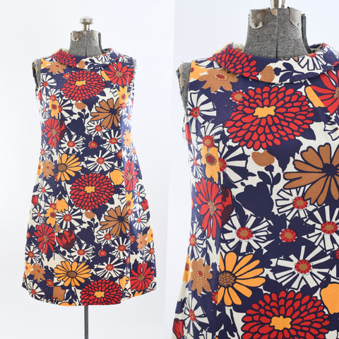 true vintage bold 1970s blue red white yellow gold large floral print sleeveless dress with rounded collar shown on dress form left image with close up of bodice details on right all on white background