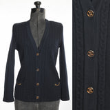 vintage 1970s V neck navy blue gold brand buttons hip pockets accented with brand chains cable knit wool Celine cardigan sweater shown on dress form left image with close up details of brand buttons right image all on white background