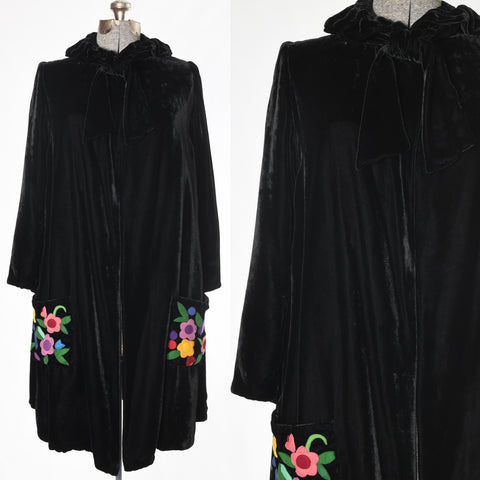 vintage 1920s black velvet midi length long sleeve open front neck tie colorful floral applique square pockets shown full coat on dress form left image and close up of bodice necktie right image on white background