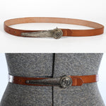 vintage 1950s brown thin leather cinch belt with silver long buckle featuring coat of arms in circle and hook to hold belt on shown lying on white background top image and on dress form bottom image