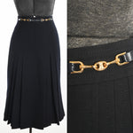 vintage 1970s dark navy blue wool midi skirt with gold Celine brand hardware and leather appliques at waistband and front double box pleats each front side skirt shown on dress form left image with close up detail of metal brand hardware right image all on white background