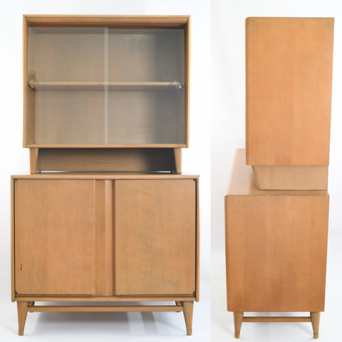 true vintage 1950s Heywood Wakefield platinum cool toned solid birch two piece china cabinet with sliding glass top shown facing forward with bottom doors closed on left image with cabinet turned to side on right image all on white background
