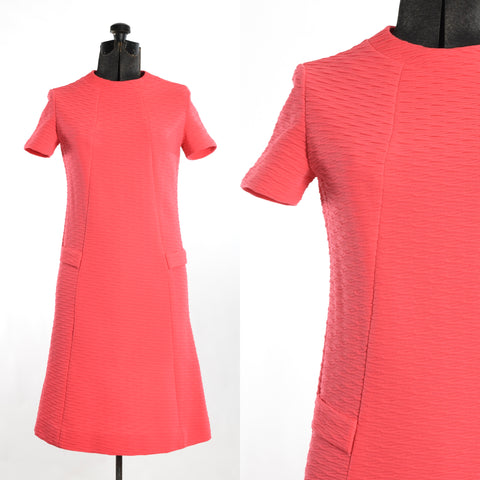 vintage 1960s bright pink a line short sleeve midi dress with round neckline and textured fabric shown on dress form left image with close up of bodice fabric details on right image with white background