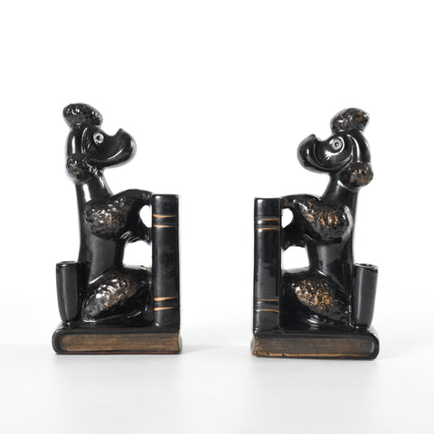 vintage 1950s set of 2 ceramic black poodles trimmed in gold paint sitting upright on books with paws against books and pen holder at back side of each dog photographed facing each other 