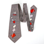 vintage 1940s black and white horizontal stripes necktie with vertical squiggle line and red, purple and white circles and rectangles lying flat on white surface folded over 3 times to show full design