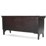 antique 16th through 18th century english oak plank coffer chest with 4 legs and reddish brown finish angled to left on white background